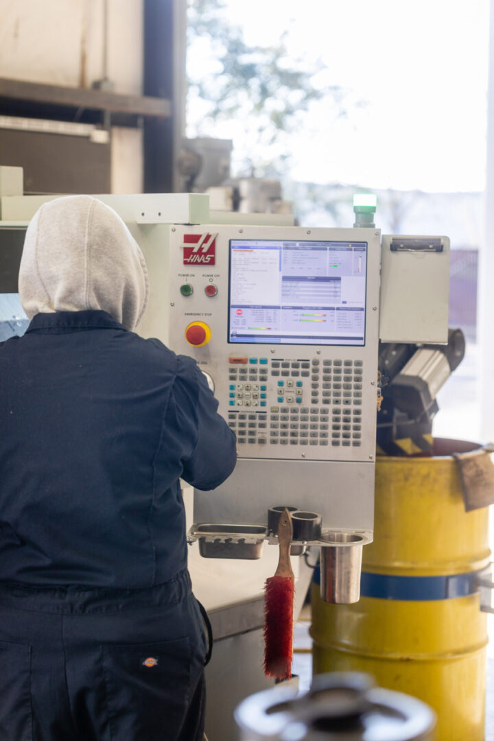 A worker operating a machining and fabrication device  