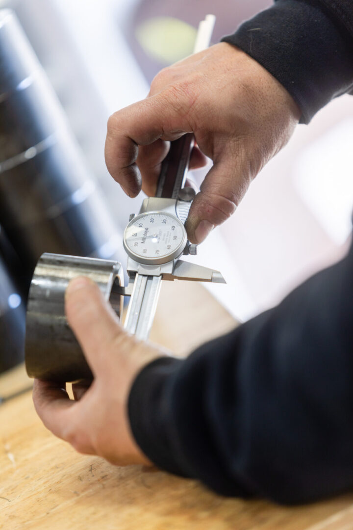 A person measuring a metal ring